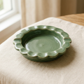 AI concept of a sage-green round ashtray with a scalloped edge